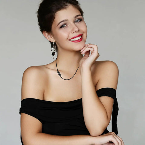 Woman wearing a necklace with black bead connector clasp showcasing fashion jewelry design