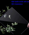 Hand holding transparent acrylic panel next to green leaves, showcasing the Durable Acrylic Display Case For 76232 Airships Model Set.
