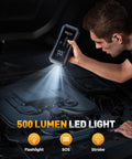 Person using 9 In 1 Jump Starter With Air Compressor 5500A 150 PSI on car engine with LED light.