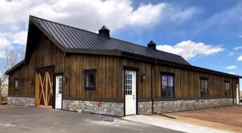 Legit Reactive Water Based Wood Stain With A Slick Reclaimed Vibe Weathered Tan Tones Hit Different On Any Surface Voc Free Solid Formula For Interior Or Exterior Jobs In 55 Gallon Drum used on a rustic wooden building with stone foundation.
