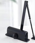 Black hydraulic buffer door closer 25 Kg to 80 Kg adjustable speed mute soft closing door hardware, surface mounted, L positioning style.