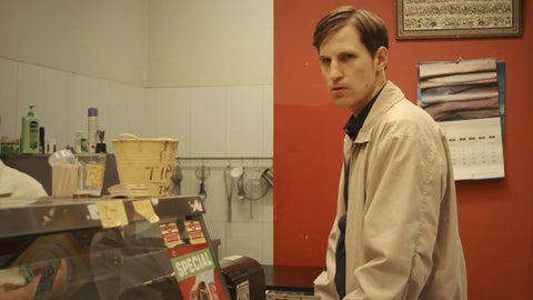 Man in shop setting from Cat Sick Blues Blu Ray Region Free Edition A Dark Gripping Gritty Indie Drama About Grief After A Cat Dies