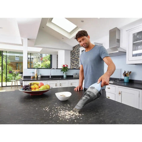 Man using a Cordless Handheld Vacuum Cleaner For Home And Car With Crevice Attachment on kitchen counter for quick cleanups and spills