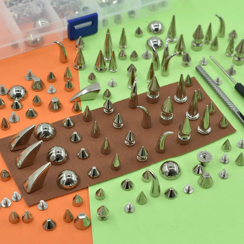 Rock Your Edge With This Kickass 150 Piece Punk Spike Rivet Kit Featuring Silver Zinc Alloy Cone Studs Screw Back Bullets And Essential Tools For Leather Crafting And Custom Apparel with various metal rivets spread out.