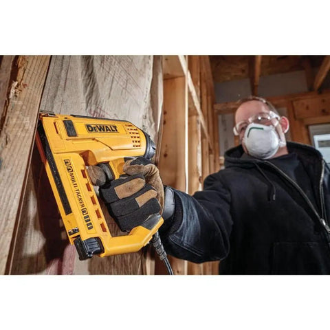 Person using Heavy Duty Electric 5 In 1 Multi Tacker for DIY projects on wooden surface indoors.