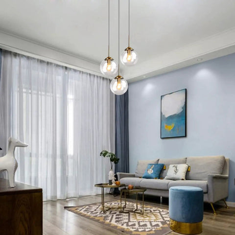 Three Light Pendant Light Fixtures With Brass Lamp Holder And Handblown Glass Shade in living room setting
