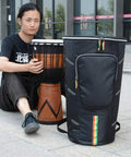 Rock Solid Protection For Your Everyday Jam, Hassle Free Djembe Gig Bag Built From Heavy Duty Oxford Fabric, Adjustable Double Straps, Water Repellent Shock Proof Case For 12 Inch African Drum, shown with a djembe.
