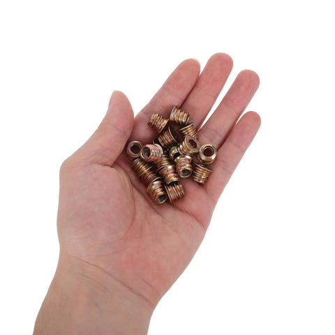 Hand holding M6x10mm Countersunk Flange Wood Nut Inserts For Cabinets And Desks No Fuss Sturdy Carbon Steel Fasteners