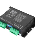 Black stepper motor driver module with two green terminal blocks and a printed wiring diagram on top.
