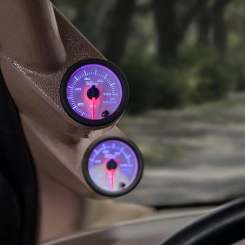 GlowShift oil pressure gauge, 52mm (2-1/16"), purple backlit dial mounted on car dash.