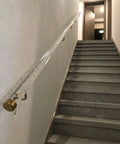Wall Mount Clear Acrylic Railing Kit With Sleek Silver Brackets For Indoor Stairs And Decks mounted along gray stairs.