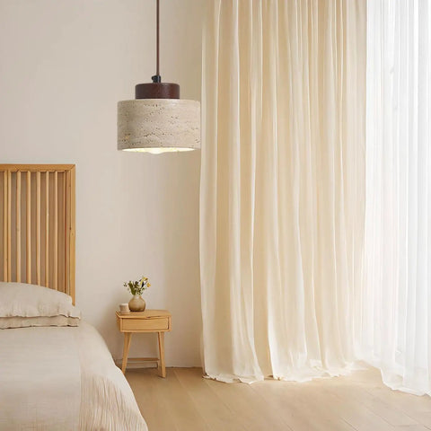 Modern Mini Pendant Light, Travertine Stone Light Fixture with Wooden Accent hanging above a bed in a cozy bedroom.