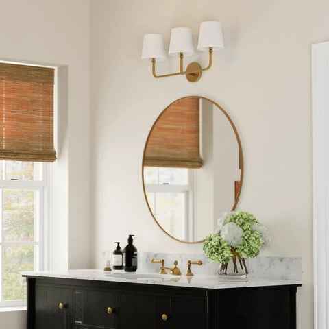 Dawson White Fabric Stay-Straight Shade Bath Vanity Light 3-Light Wall Mount in Aged Brass above a bathroom mirror