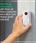 Wireless Smart Home Security Video Doorbell Offering Rock Solid Head To Toe HD View And Two Year Battery Life With No Sweat Easy Setup including a hand mounting the doorbell on a wall.