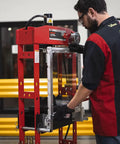 Man operating 20 Ton Hydraulic Shop Press With Dual Air Motor And 7 Position Bed Height Polycarbonate Shield