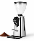 Top Shelf 64mm Flat Burr Coffee Grinder For Espresso Machines And Pour Over Brews With Dead On Grind Precision Single Double Dose Control And Zero Mess Silver Chute with silver casing and coffee grounds beside it.