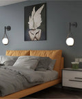 Modern Globe Wall Sconce Set Of 2 Black Glass Drop Lights flanking bed, frosted glass balls, minimalist water drop design, bedroom.