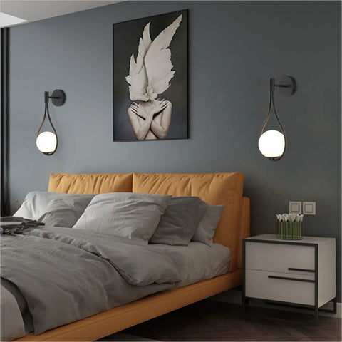 Modern Globe Wall Sconce Set Of 2 Black Glass Drop Lights flanking bed, frosted glass balls, minimalist water drop design, bedroom.