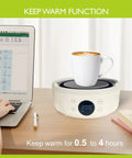 Ultra Compact 600W Electric Mini Hot Plate With Nine Precise Heat Settings keeping a coffee cup warm on a desk next to a laptop.