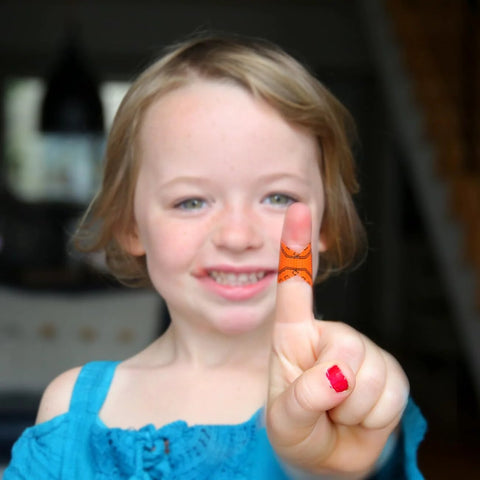 Medical tape wrapped around a fingertip; orange adhesive tape held up by a smiling child.