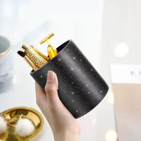 Hand holding a Glitter Desk Pen Holder Organizer For Office And Home Leather Look Pencil Cup filled with brushes and tools