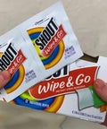 Person holding Shout Instant Stain Remover Wipes 12 Count, 5 By 6 Inch Towelettes for quick stain removal.