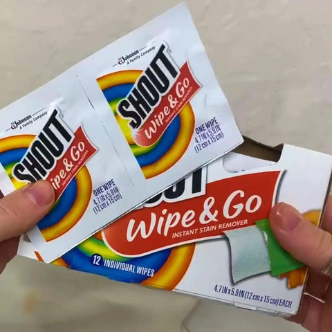 Person holding Shout Instant Stain Remover Wipes 12 Count, 5 By 6 Inch Towelettes for quick stain removal.