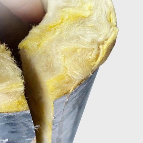 Close-up of yellow rock wool fibers in a Heavy Duty Rock Wool Pipe Shell High Temperature Insulation with aluminum foil cover.
