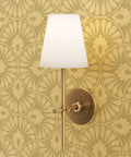 Glow Up Your Space With Top Shelf Abstract Scalloped Gold Metallic Wallpaper For Modern Interiors with a gold wall sconce.