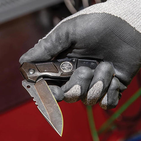 Klein Tools 44228 folding pocket knife; side view, black handle, stainless blade, bearing-assisted flipper, belt clip.