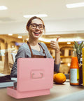 Smiling person using large pink cash box with money tray and key lock for cash till at a market counter