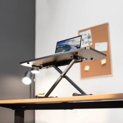 Black 28 Inch Standing Desk Converter Sit To Stand Monitor Riser With Scissor Lift Height Adjustment shown on office desk