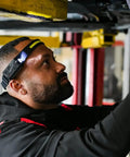 Mechanic using Ultra Bright 5 Mode LED Headlamp for Adults with hands-free illumination, working under a car.
