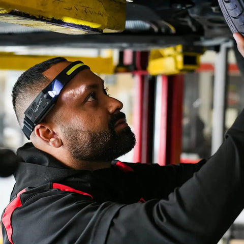 Mechanic using Ultra Bright 5 Mode LED Headlamp for Adults with hands-free illumination, working under a car.