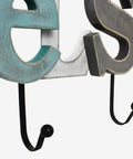 Close-up of rustic wooden sign with cutout letters and towel hanging rack, highlighting dual hooks and distressed paint, perfect for farmhouse decor.