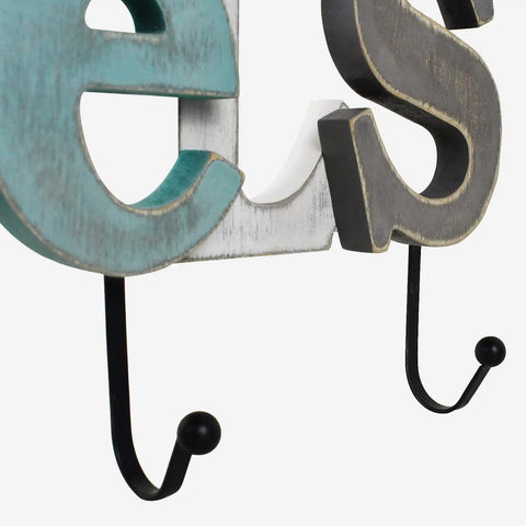 Close-up of rustic wooden sign with cutout letters and towel hanging rack, highlighting dual hooks and distressed paint, perfect for farmhouse decor.