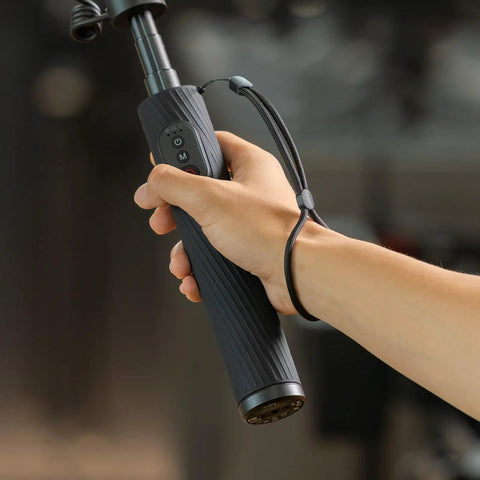 Hand holding Power Grip With Built In 5000mAh Battery For Action Cameras And Phones Wireless Control Selfie Stick in use