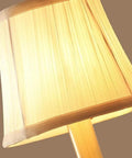 Close-up of modern brass wall lamp with white cotton drum shade matte warm antique finish easy install sconce for living room
