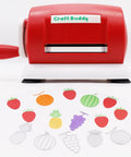 Red manual die cutting and embossing machine for DIY projects with fruit-shaped die cuts displayed in front.