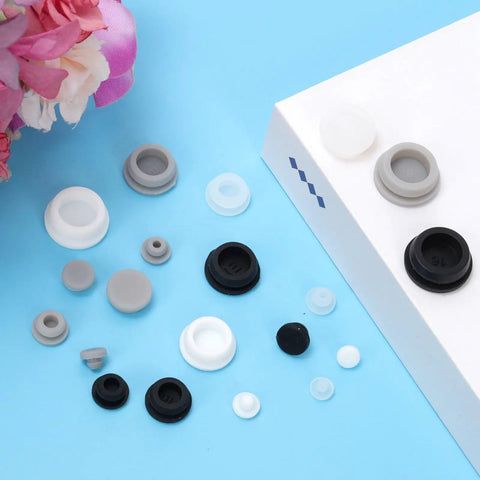 Ultimate 120 Piece Grey Silicone Hole Plug Pack With 9 Sizes For Furniture Legs And Cabinet Doors, Reusable Round Rubber Covers Perfect For Sealing Gaps And Keeping Things Snug On Any Project. Grey, white and black silicone hole plugs in assorted sizes on a blue surface