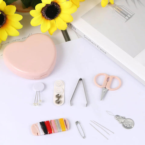 Heart Shaped Portable Travel Sewing Kit For On The Go Fixes Mini Box With Threads Scissors Hand Sewing Needles DIY Repair Tools Pink Compact Handy Essentials For Quick Mends displayed on a table with yellow flowers