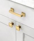 Gold cabinet handle and knobs on white cabinet doors in kitchen.