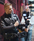 Videographer using Thanos Pro Gimbal Vest Stabilizer System With Adapter Arm For All Day Filming in urban setting
