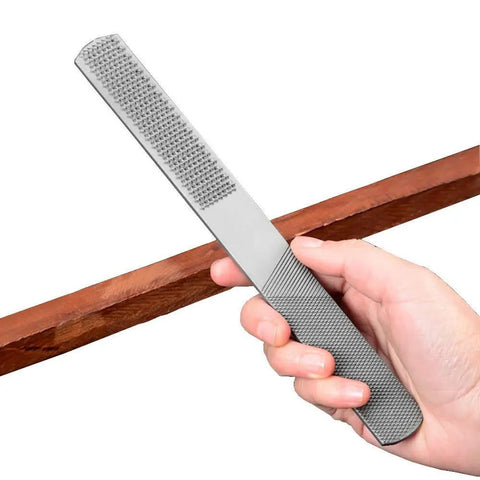 Hand holding flat file from Two Pack 4 Way Wood Rasp File Set With Premium High Carbon Steel, used for sharpening wood tools.