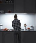 Person using Plug In 24 Inch Under Cabinet Light Bar With Wave Sensor for kitchen task lighting, touchless dimming.