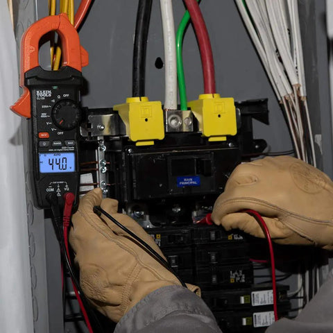 Electrician using Digital Clamp Meter With Auto-Ranging 400 Amp AC, Measures AC/DC Voltage, Resistance And Continuity in a panel box.