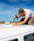 Man applying RV Roof Sealant Kit 4 Pack Self Leveling Lap Sealant In White Easy Leak Fix for Travel Trailers And Motorhomes on RV roof.