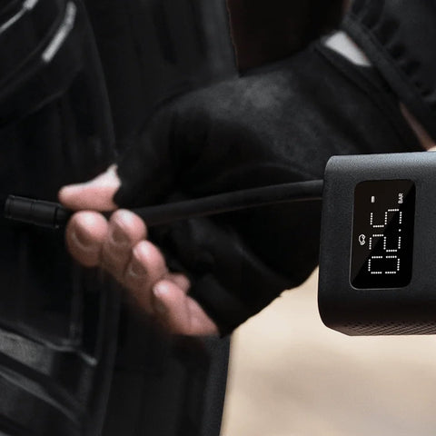 Hand using Portable Electric Air Compressor 2 with 150 Psi, Fast Inflate for cars, trucks and bikes, digital display shown