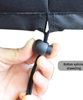 Hand adjusting elastic hem cord on waterproof Oxford cloth spreader cover for mini broadcast spreader 25.9 by 25.9 inches.
