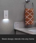 2 Pack LED Night Light For Single Pole Switches with white finish illuminating a bathroom wall beside an orange towel